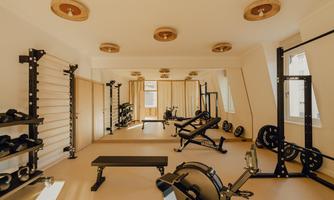A modern gym with weights and training equipment. Large mirrors and plenty of natural light create an inviting atmosphere.