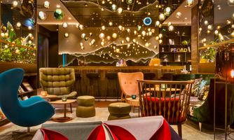 A modern lounge café with stylish furniture and warm lighting. The striking lamps create an inviting atmosphere.