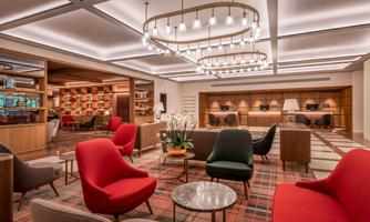 An elegant lounge area with modern furniture in various colors. Warm lighting and an inviting atmosphere create a comfortable space for relaxation.