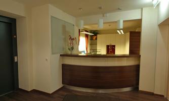 A modern reception area with a wooden counter and bright walls. The room has an inviting and clean appearance.