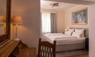 A cozy bedroom with a double bed and soft pillows. A lamp and a mirror give the room an inviting atmosphere.