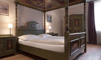 A cozy bedroom with a sky-blue bed and a decorative canopy bed. The room is bright and furnished in a modern style with a wardrobe and nightstands.