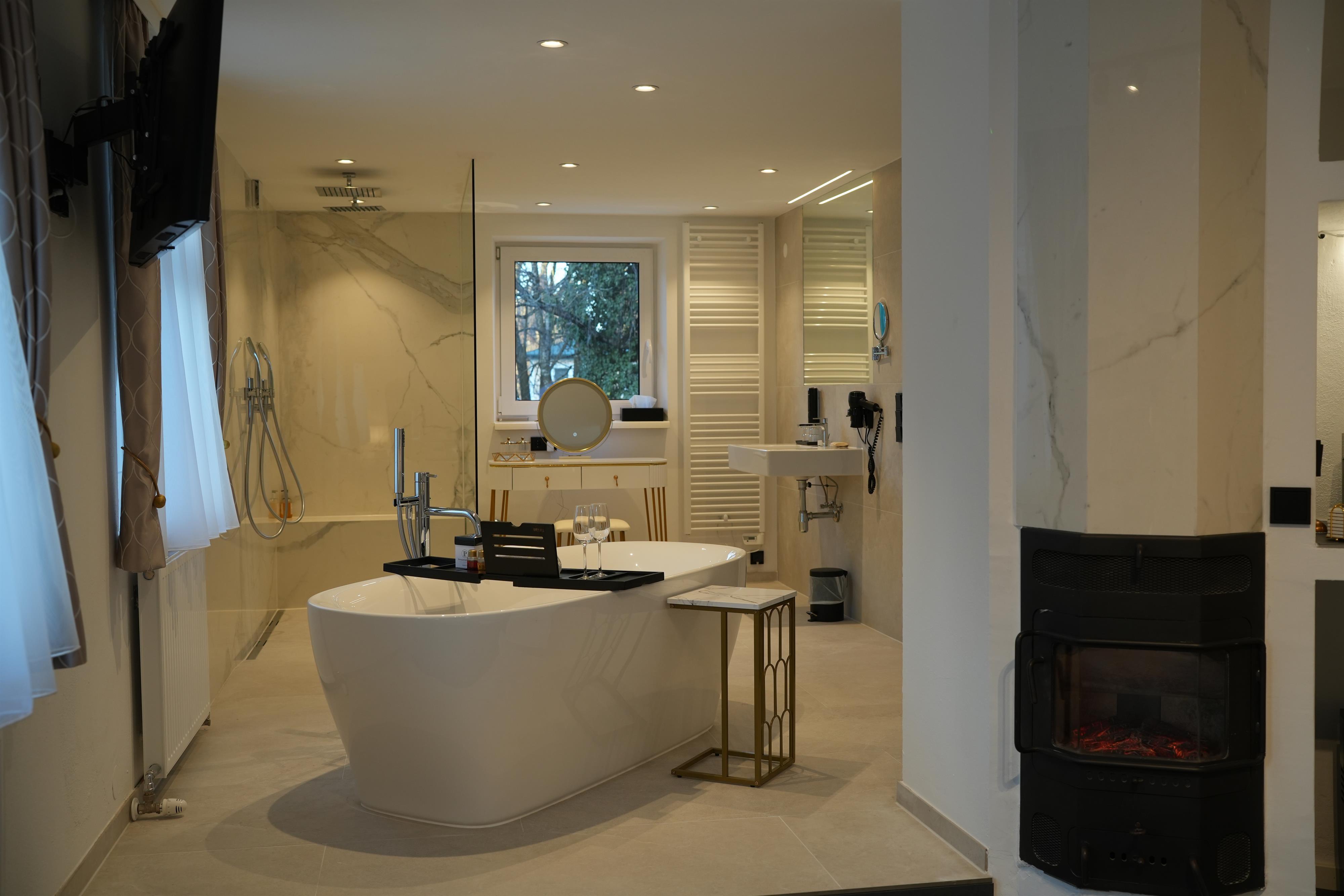 A modern bathroom with a freestanding bathtub and elegant fixtures. Large windows provide plenty of natural light.