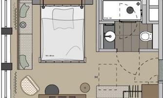 A simple floor plan drawing of a room. It shows a bedroom, a bathroom, and a living area with furniture.