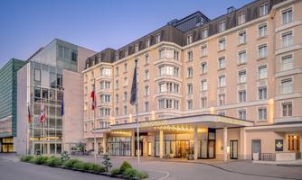 An elegant hotel building with modern and classic design. The entrance area is inviting and warmly lit.