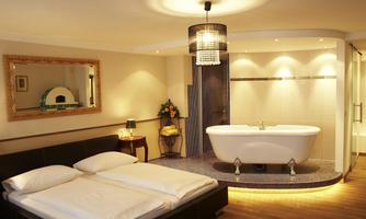 A cozy bedroom with a double bed and an elegant bathroom in the background. The atmosphere is bright and inviting, featuring modern design elements.