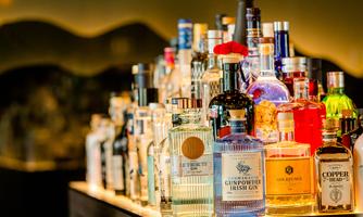 A stylish bar with a variety of spirits bottles. The bottles are colorful and attractively arranged.