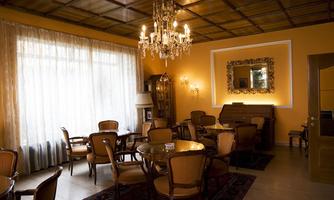 An elegant café with wooden chairs and a chandelier. The walls are painted in warm shades of yellow, and large windows let in plenty of light.