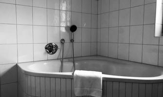 A modern bathroom with an elegant bathtub. A towel is lying on the edge of the bathtub.
