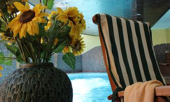 A relaxing area with a swimming pool, a deck chair, and a vase with sunflowers. The atmosphere is calm and inviting.