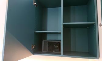 An open blue cabinet with several compartments. In the lower corner, there is a small safe.