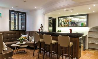 An elegant bar with bright walls and a modern counter. The seating areas are cozy and provide an inviting atmosphere.