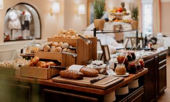 A buffet with fresh rolls, jam, and fruit. The atmosphere is inviting and cozy.