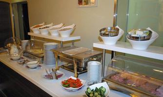 A well-set buffet table with various bowls and dishes. There are fresh vegetables, salads, and various side dishes.