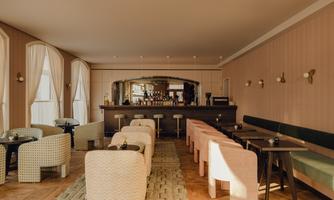 A stylish café with cozy seating areas and a well-equipped bar. Large windows let in plenty of daylight.