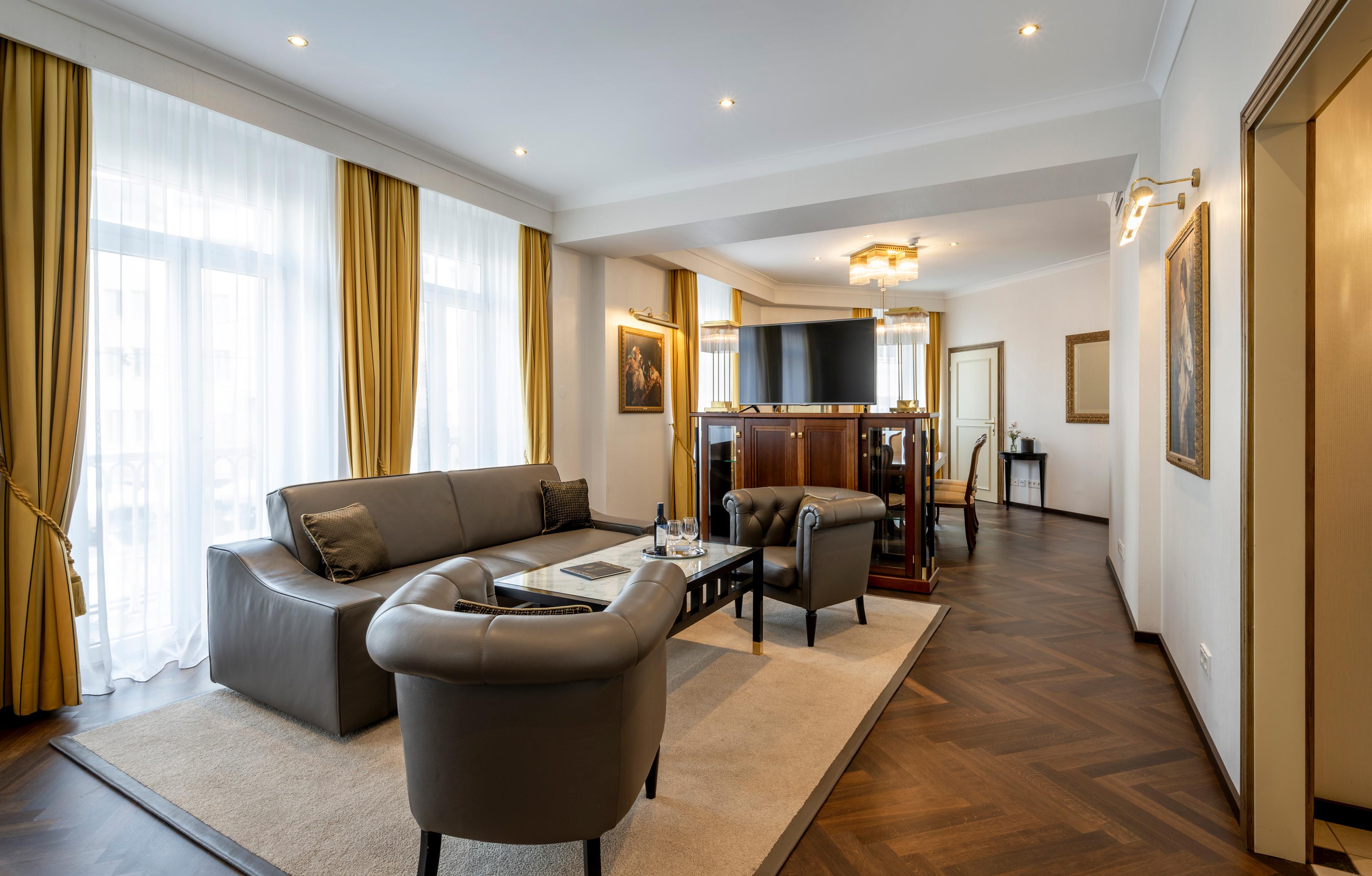 A modern living room with elegant furniture and large windows. The warm colors create a cozy atmosphere.