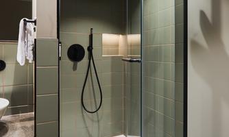 A modern shower with a glass enclosure and elegant fixtures. The walls are in neutral tones, creating a calming impression.