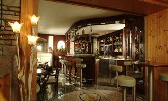 An elegant bar with wooden paneling and stylish seating options. The illuminated flowers create a cozy atmosphere.