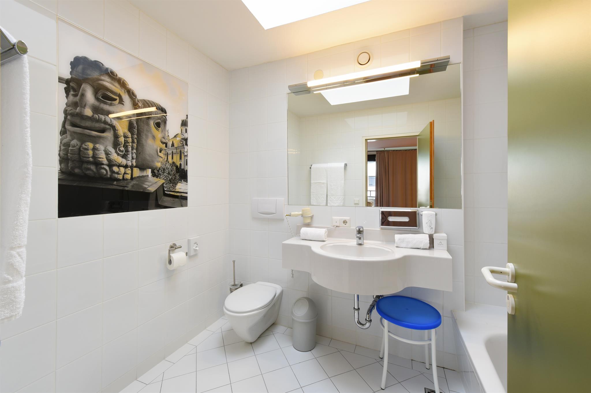 A modern bathroom with a bright color tone. In the background, there is a large photo of a statue on the wall.