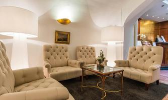 A stylish lounge with beige armchairs and an elegant table. Soft lighting creates a cozy atmosphere.