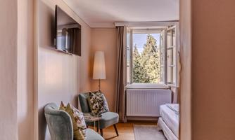 A bright room with two stylish armchairs and a window that overlooks a green view. The decor is modern and welcoming.