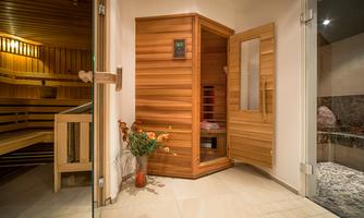A relaxing wellness area with a modern sauna. The room is bright and friendly, equipped with a small flower arrangement.