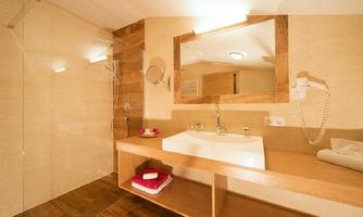A modern bathroom with a shower and an elegant sink. Wood and stone materials create a stylish atmosphere.