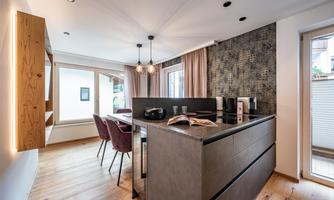 A modern kitchen with an elegant dining table and stylish chairs. Bright colors and plenty of natural light create an inviting atmosphere.