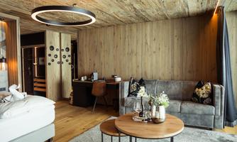 A modern room with wood paneling and stylish furnishings. A comfortable couch and a desk create a cozy atmosphere.