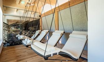 A relaxing space with hanging loungers and modern wood design. The soft lighting and calm atmosphere invite you to unwind.