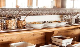 A beautifully set buffet area with several bowls for different foods. The atmosphere is cozy and inviting.