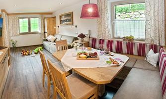 A cozy living space with a dining group and a comfortable couch. Various dishes are arranged on the table.