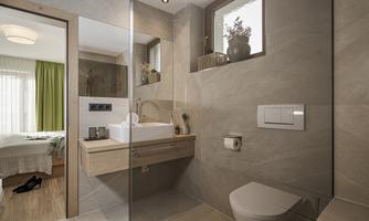 A modern bathroom with stylish tiles and a large mirror. The room is bright and cozy, with a window and a view of an adjacent room.