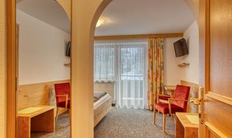 A cozy room with wooden details and red chairs. The room is bright and inviting, with windows that let in natural light.